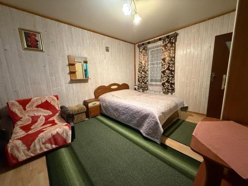 a small bedroom with a bed and a chair at healing waters in Skhidnitsa