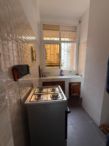 a kitchen with a stove and a sink in it at Bright Dakar Plateau Apartment in Dakar
