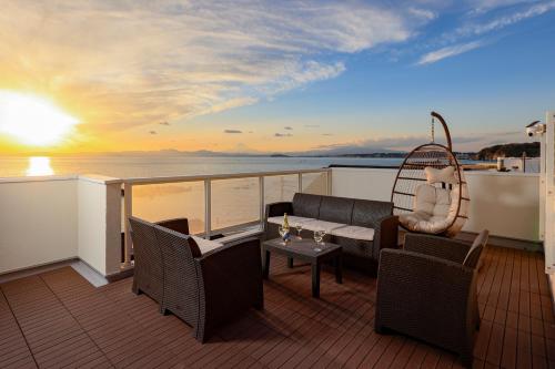 a balcony on a cruise ship with a couch and a swing at ファブール葉山別邸 海岸まで徒歩15秒の富士山と夕陽を望む海辺のお家 in Hayama