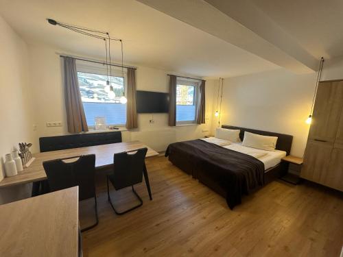 a bedroom with a bed and a table in it at Willi's Holidays Home in Saalbach-Hinterglemm
