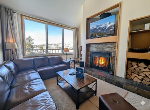 a living room with a couch and a fireplace at Pines 2129 by SummitCove Lodging in Keystone