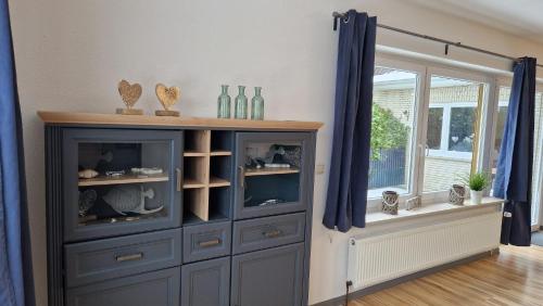 a blue hutch with bottles and vases on it at Ferienwohnung Dons in Grömitz