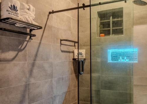 a shower with a glass door in a bathroom at Rooks Rest Inn & Apartments in Lagos