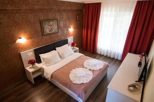 a bedroom with a bed with two flowers on it at Danubiu Resort in Murighiol