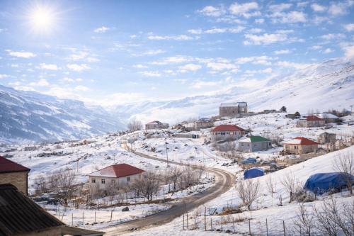 a small village in the snow on a mountain at Shahdag Cozy House in Qusar