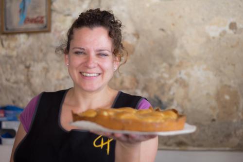 a woman holding a hot dog on a plate at Petit Hotel Hostatgeria La Victoria in Alcudia