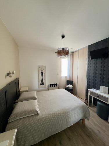 a bedroom with a large bed and a television at Hôtel le midi in Montaigu-de-Quercy