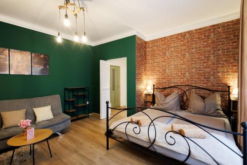 a bedroom with a brick wall and a bed and a couch at Eperke Apartmanok in Balatonfüred