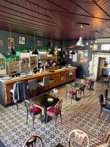 a restaurant with tables and chairs and a counter at Hôtel le midi in Montaigu-de-Quercy