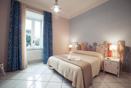 a bedroom with a bed with blue curtains and a window at La Tartaruga in Salerno