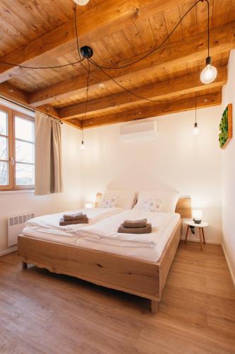 a large bed in a room with a wooden ceiling at Neobyčejný Sklep in Pavlov