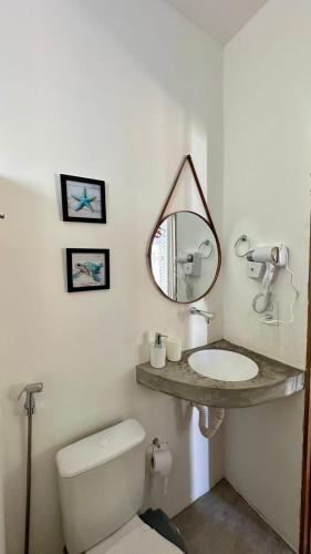 a bathroom with a toilet and a sink and a mirror at Chalé Begê in Barra Grande
