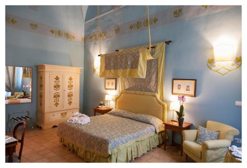 een slaapkamer met een bed en een stoel bij Palazzo Guiderocchi in Ascoli Piceno