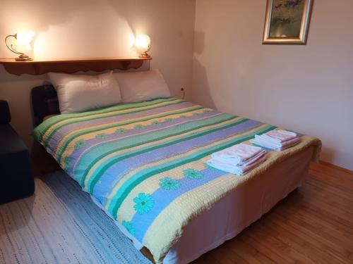 a bed with a colorful blanket on it in a room at Kuća za odmor Silver pine in Ogulin