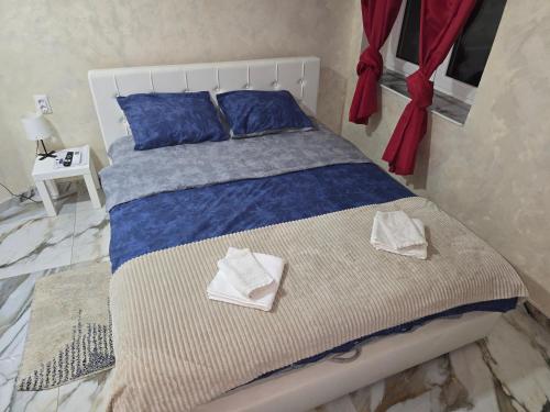 a bed with blue pillows and towels on it at Motel Gas in Belgrade
