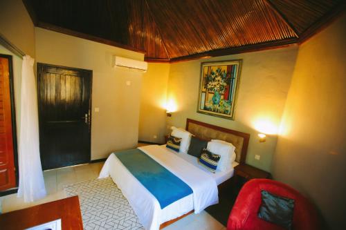 una camera da letto con un letto grande e una sedia rossa di Songon Park Resort a Songon-Agban