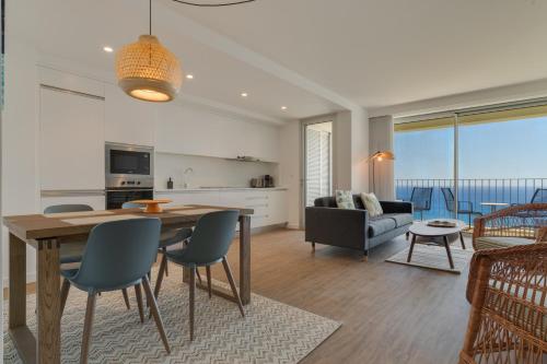 a kitchen and living room with a table and chairs at Pearl Retreat by Holiday Rental Madeira in Câmara de Lobos