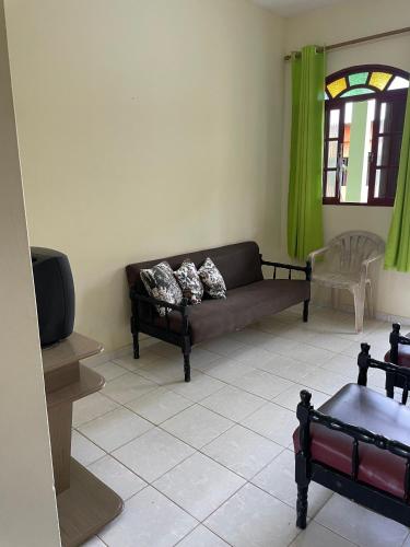 a living room with a couch and a tv at Apartamentos Dona Marlene in São Francisco de Itabapoana