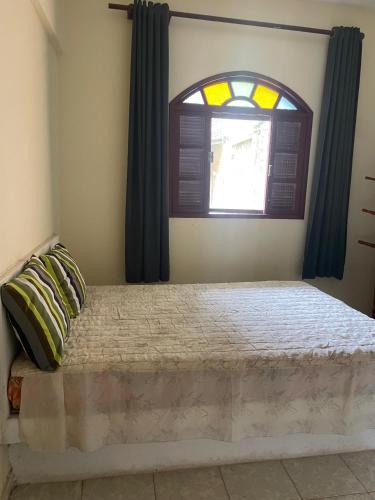 a bedroom with a large bed with a window at Apartamentos Dona Marlene in São Francisco de Itabapoana