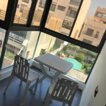 a table and two chairs in a room with a window at La corniche in Kenitra