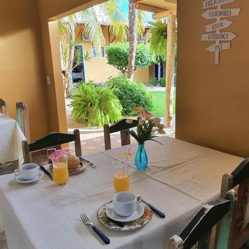 a table with a white table cloth and drinks on it at Pousada 2 Rios Comfort in Barra do Garças