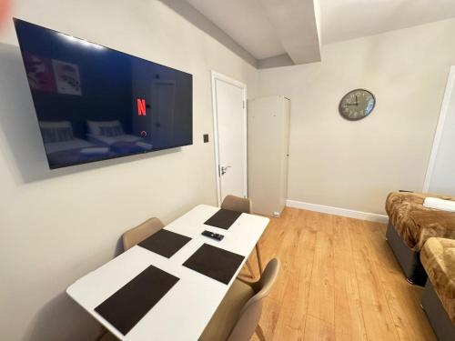 a dining room with a white table and chairs at New Kings Cross Apartment in London