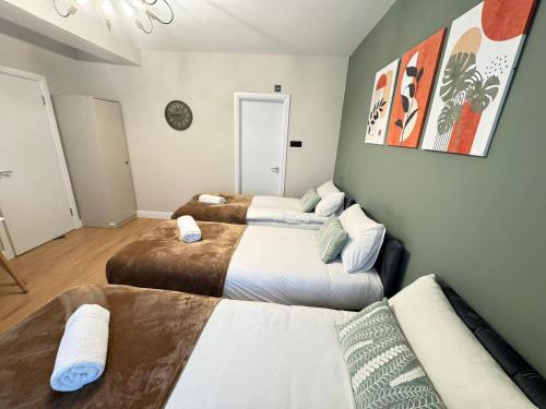 a room with three beds and a chandelier at New Kings Cross Apartment in London