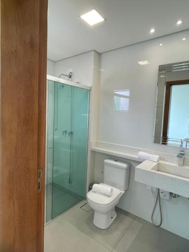 a bathroom with a toilet and a shower and a sink at Rincão Resort in São Paulo