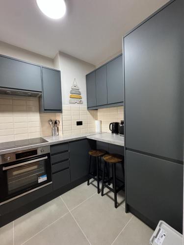 a kitchen with black cabinets and black appliances at New Kings Cross Apartment in London