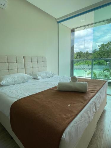 a bedroom with a large bed with a large window at Rincão Resort in São Paulo