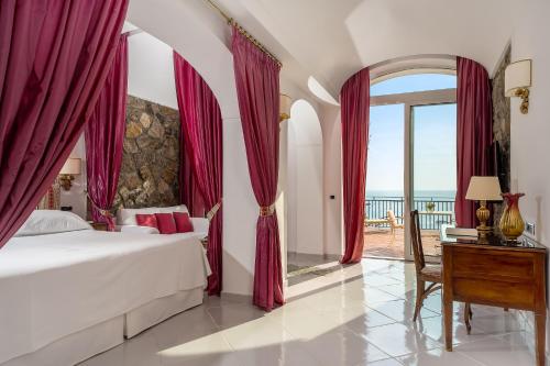a bedroom with a bed and a view of the ocean at Hotel Santa Caterina in Amalfi