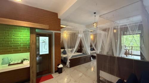 a large room with a bedroom with a bed and a bathroom at Evergreen Cottage in Ella