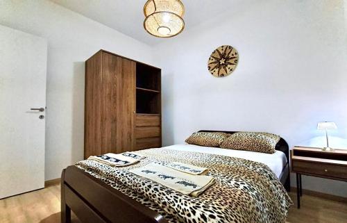 a bedroom with a leopard print bed and a clock at Upendo Apartment in Vrnjačka Banja