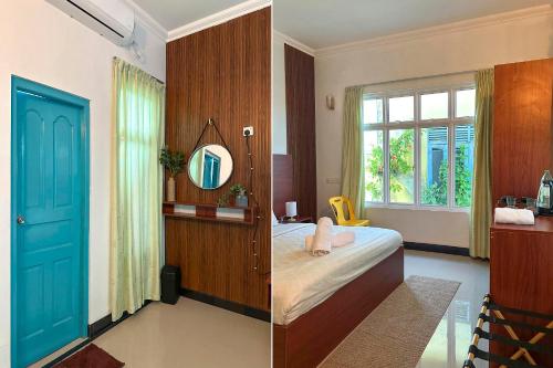 a bedroom with a bed and a blue door at Filladhoo inn in Filadu