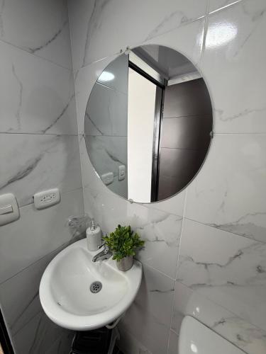 a white bathroom with a sink and a mirror at Descansa, comodidad y confort in Manizales