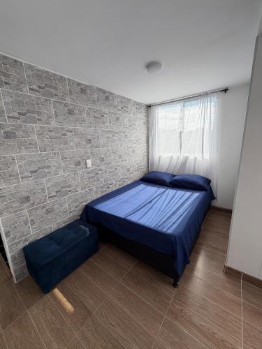 a bedroom with a bed and a brick wall at Descansa, comodidad y confort in Manizales