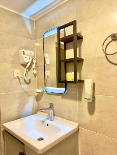a bathroom with a sink and a mirror at The Heritage Inn in Disah