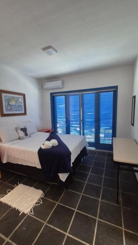 a bedroom with two beds and large windows at Magia D'ajuda Hospedagem - Centrinho, próximo à Mucugê in Arraial d'Ajuda