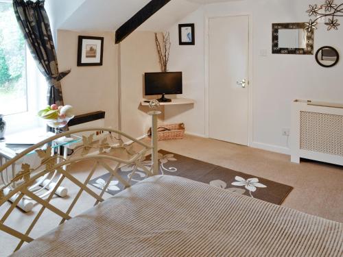 a living room with a glass table and a television at Rosecraddoc Manor - Heron in Saint Cleer