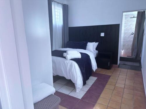 a bedroom with a bed with two towels on it at SA Guest House in Roodepoort