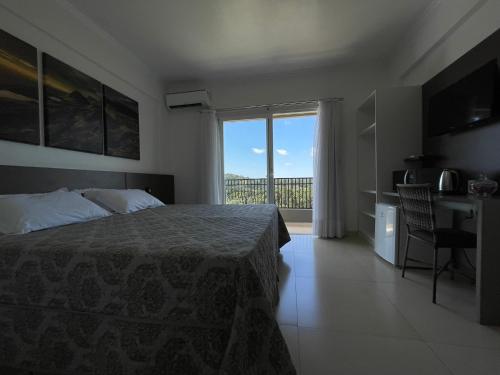 a bedroom with a bed and a view of a balcony at Hotel Queijo & Cia in Capão Alto