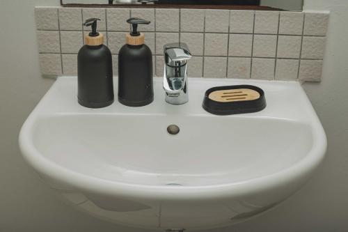 a white sink with two black bottles on it at Ballito Seasons in Ballito