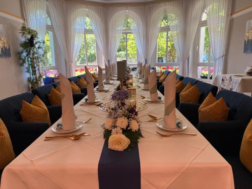 a long table in a room with chairs at Hotel & Restaurant Bellevue Schmölln in Schmölln