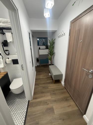 a bathroom with a toilet and a sink and a door at Garsoniera G 5 in Roman