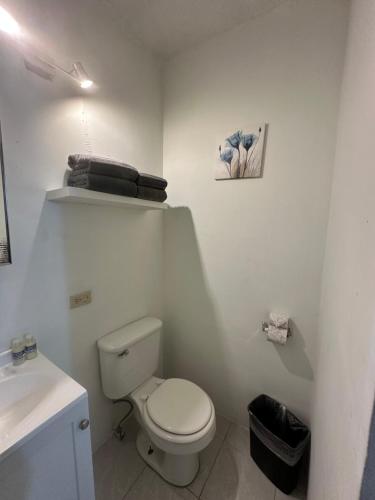 a white bathroom with a toilet and a sink at Rosarito By The Sea in Rosarito