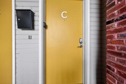 a yellow door with a tv on top of it at Stylish STL Gem ABODEbucks in Saint Louis