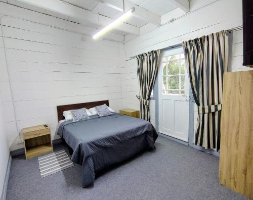 a bedroom with a bed and a large window at Her Home in Purranque