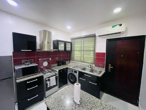 a kitchen with a stove and a sink in it at Blue Bell Suites in Lekki