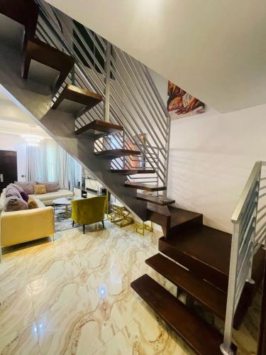 a living room with a staircase in a house at Blue Bell Suites in Lekki