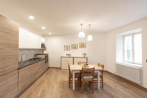 a kitchen and dining room with a table and chairs at La bottega del sarto in Grumes